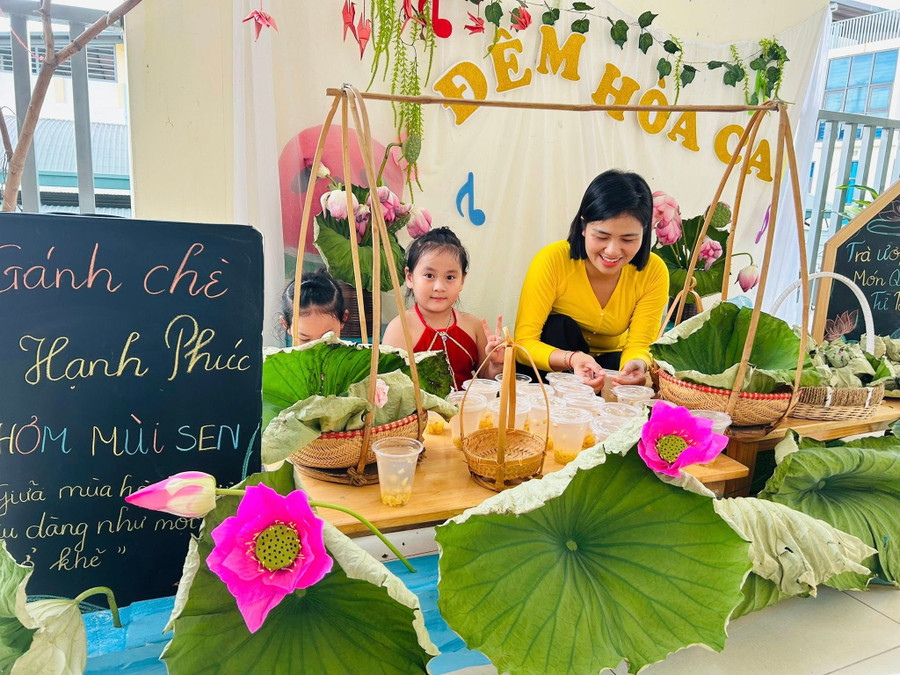 Cô giáo hướng dẫn trẻ 5 tuổi tại Trường Mầm non An Khánh B (Hà Nội) các bước để ướp chè sen. Ảnh: Khôi Nguyên.