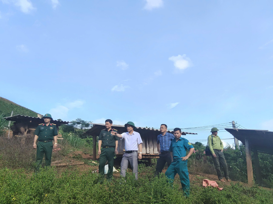 Ông Nguyễn Văn Bách, Chủ tịch UBND xã Pú Nhung (áo trắng đứng giữa) chỉ đạo di dời các hộ dân nằm trong khu vực xung yếu, nguy cơ bị ảnh hưởng do sạt lở.