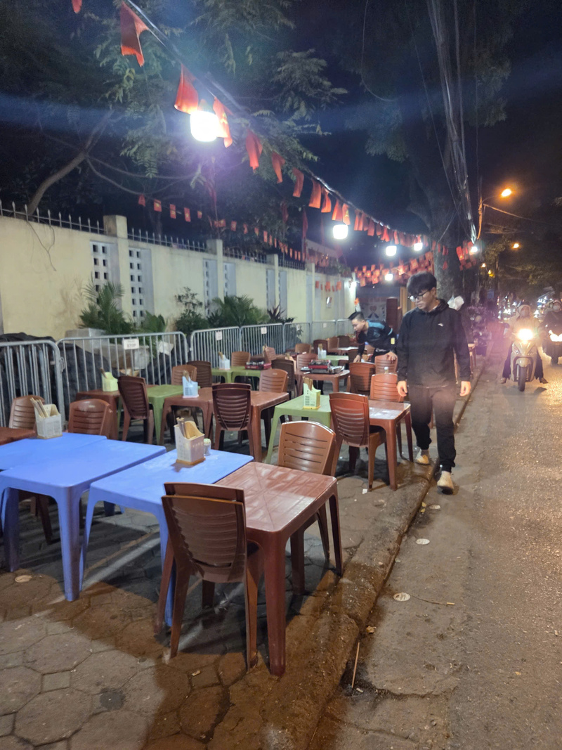 Một quán bán đồ nướng ấn chiếm vỉa hè làm nơi kê bàn ghế từ lúc còn chưa có khách.