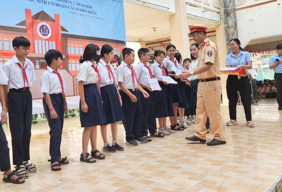 Đại úy Trịnh Trung Hiếu - Bí thư Chi đoàn Thanh niên phía Nam Cục CSGT trao học bổng cho học sinh. 1000126612.jpg