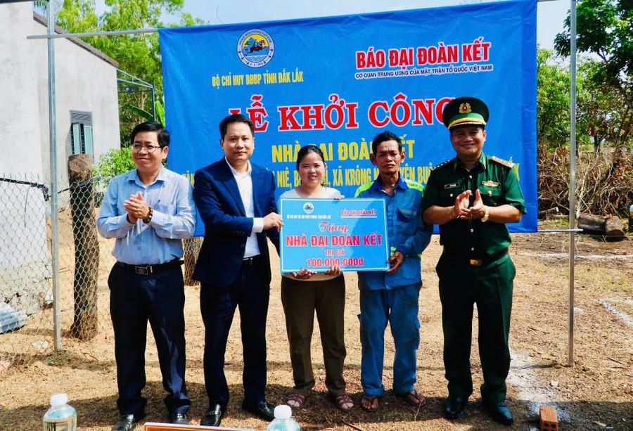 Nhà báo Trương Thành Trung, Tổng Biên tập Báo Đại Đoàn Kết cùng Đại tá Rơ Lan Ngân, Phó Chính ủy, Bộ đội Biên phòng tỉnh Đắk Lắk; lãnh đạo xã Krông Na trao bảng tượng trưng cho gia đình ông Y Hớn Niê. Ảnh: Thanh Nga.