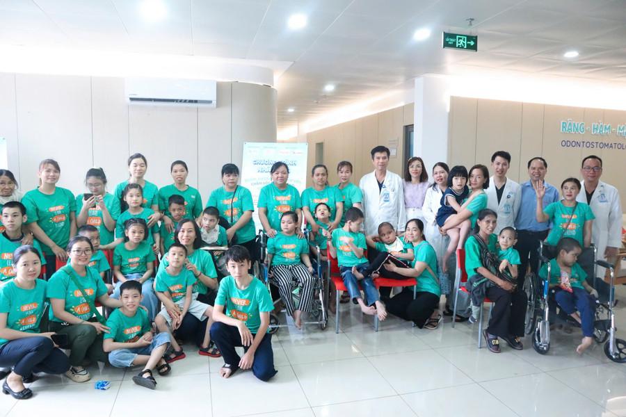 Gia đình các em nhỏ chụp hình lưu niệm cùng các y, bác sĩ tại Chương trình. (Ảnh: TT) 4-te.jpg