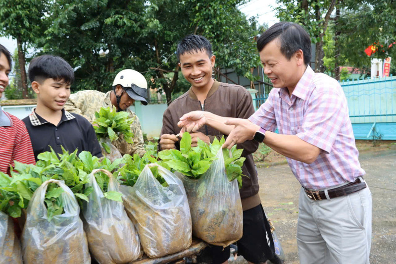 Chủ tịch UBND xã Tu Mơ Rông Trần Quốc Huy trao cây giống cà phê của doanh nghiệp tặng cho người dân trên địa bàn xã. Ảnh: Bình An