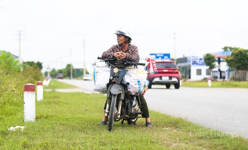 Nhiều bà con đứng trên bờ nóng lòng chờ đợi máy gặt đến ruộng mình