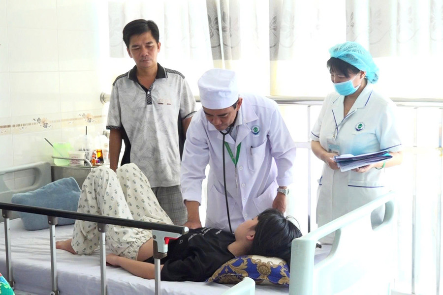 Bác sĩ CKII Nguyễn Huỳnh Nhật Trường thăm khám cho bệnh nhi mắc sốt xuất huyết. Ảnh: Yến Phương.