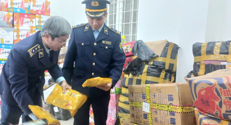 Lực lượng QLTT kiểm tra hàng giả, hàng lậu sau khi thu giữ. Ảnh: Nguyễn Tuấn