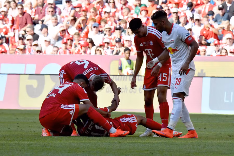 Sự cố đầu tiên xảy ra ở phút 83 trận gặp RB Leipzig. Chỉ khoảng 2 phút sau khi ghi bàn nâng tỷ số lên 3-1, Musiala có biểu hiện mất phương hướng, đứng không vững rồi từ từ khuỵu xuống sân. Tiền vệ Ismael Saibari kịp lao tới đỡ đồng đội, trước khi Joshua Kimmich cùng nhân viên y tế hỗ trợ. Ảnh: Reuters. 7.jpg